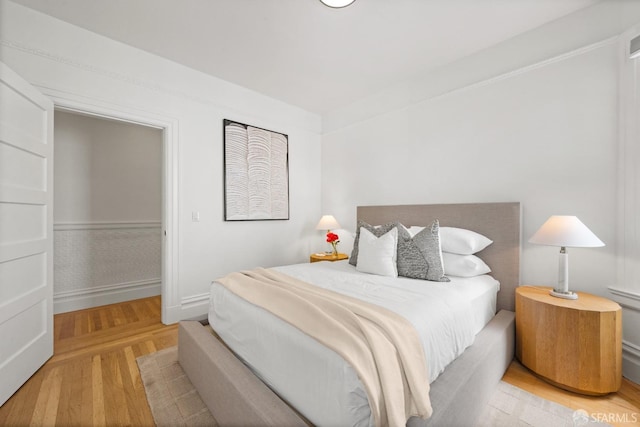 bedroom with wood finished floors and baseboards