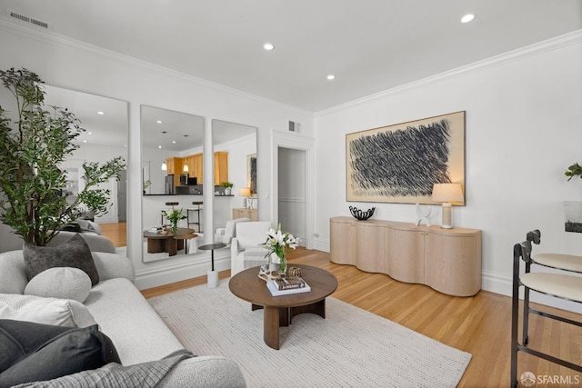 living room with wood finished floors, crown molding, recessed lighting, and baseboards