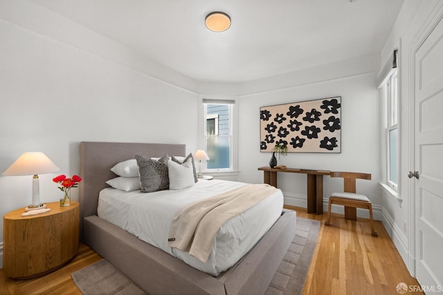 bedroom featuring wood finished floors and multiple windows