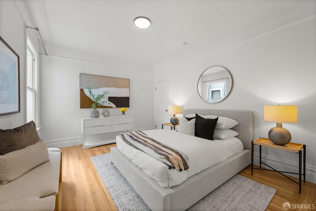 bedroom with wood finished floors and baseboards