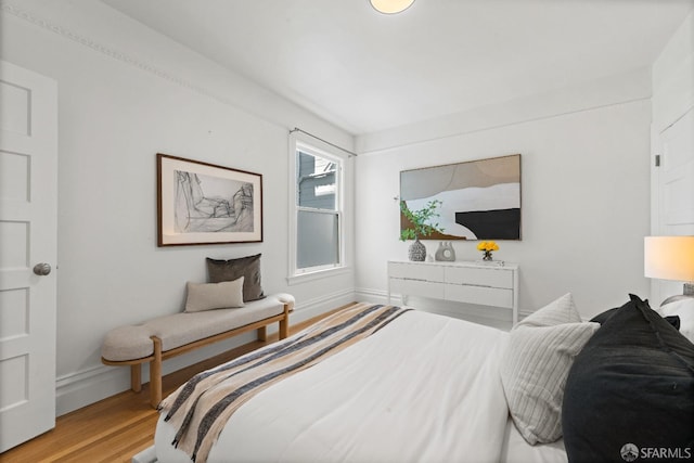 bedroom with baseboards and wood finished floors