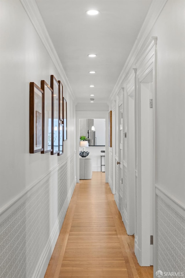 hall with wainscoting, recessed lighting, light wood finished floors, and ornamental molding