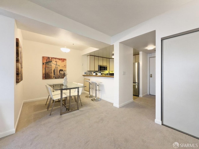 dining area featuring light carpet