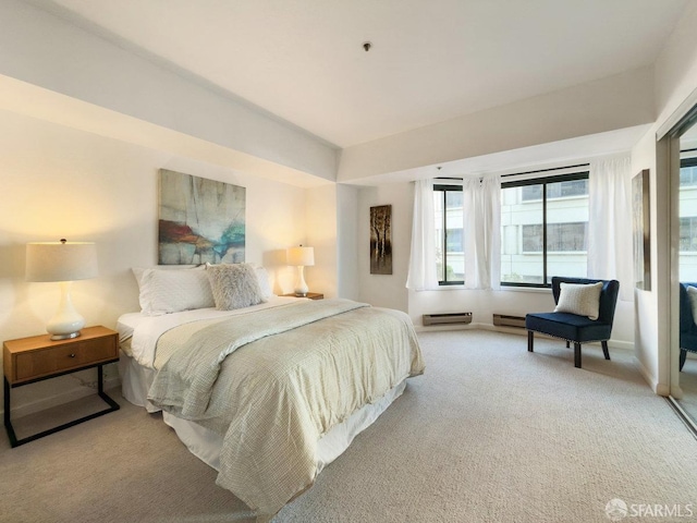 bedroom featuring a baseboard heating unit and light colored carpet