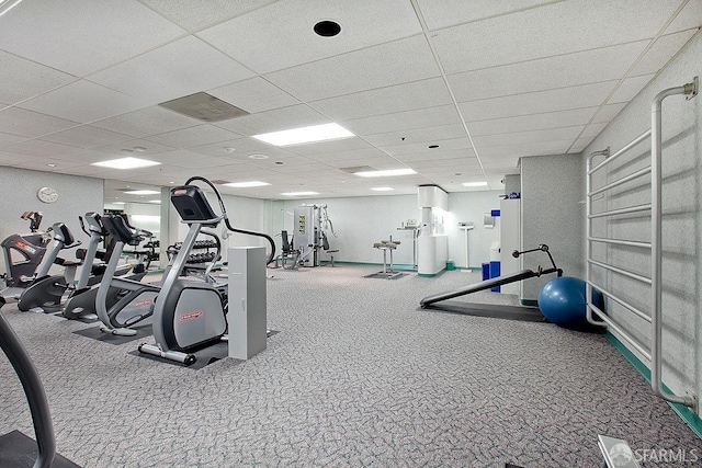 workout area with a paneled ceiling and carpet