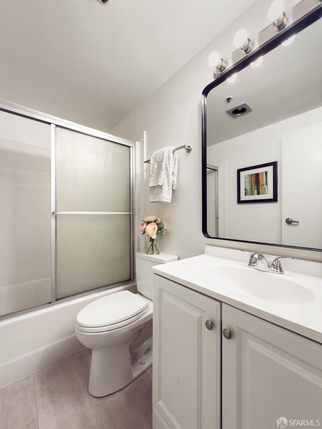 full bathroom with tile patterned flooring, vanity, shower / bath combination with glass door, and toilet