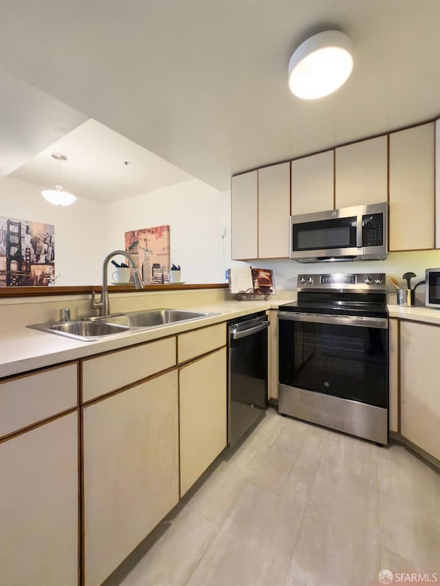 kitchen with light hardwood / wood-style flooring, sink, cream cabinets, and stainless steel appliances