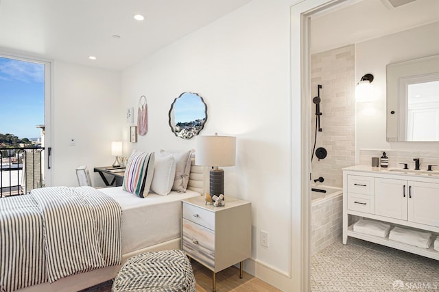 bedroom with ensuite bath, recessed lighting, a sink, and access to exterior