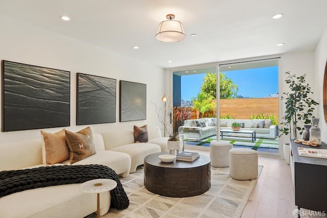 living area with light wood-type flooring, expansive windows, and recessed lighting