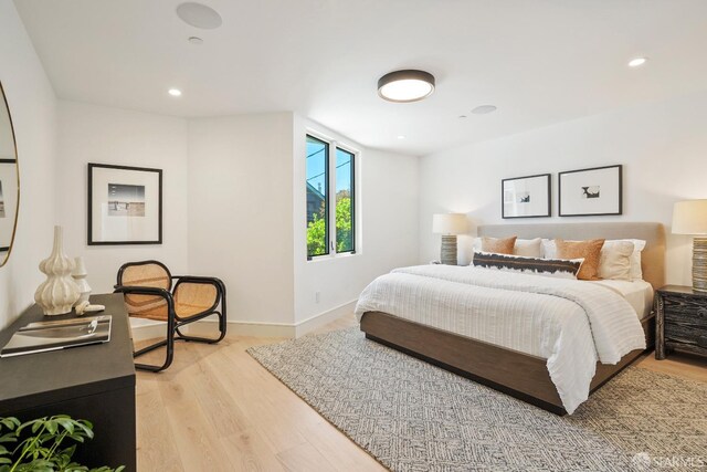 bedroom with baseboards, recessed lighting, and light wood-style floors