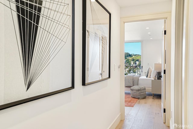 hallway featuring baseboards, wood finished floors, and recessed lighting