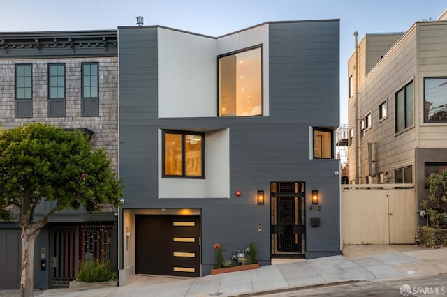 view of front of home featuring an attached garage and fence