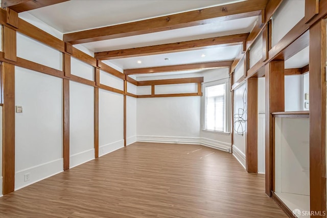 interior space with beam ceiling and light wood-type flooring