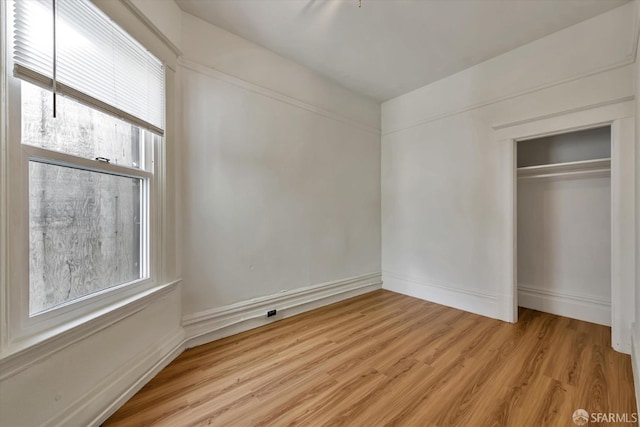 unfurnished bedroom featuring a closet and light hardwood / wood-style floors