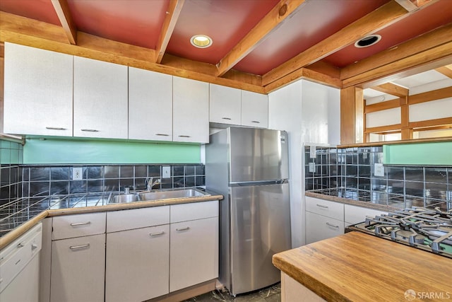 kitchen with tasteful backsplash, stainless steel refrigerator, and white cabinetry