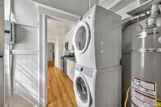 laundry room featuring light hardwood / wood-style floors, strapped water heater, ornamental molding, and stacked washer and clothes dryer