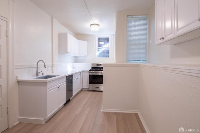 kitchen featuring white cabinets, light hardwood / wood-style floors, sink, and stainless steel stove