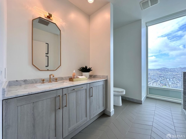 bathroom featuring toilet, a mountain view, vanity, and tile patterned floors