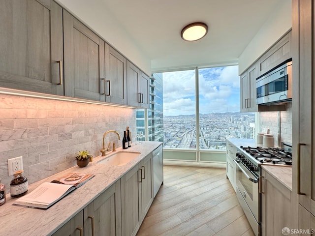 401 Harrison St Unit 48C, San Francisco, CA 94105 - kitchen with backsplash, appliances with stainless steel finishes, a sink, a view of city, and light wood finished floors