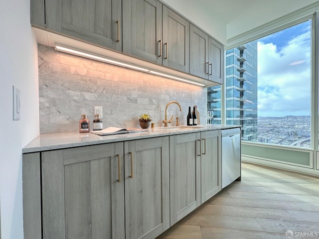401 Harrison St Unit 48C, San Francisco, CA 94105 - bar with backsplash, a sink, light wood-style flooring, and dishwasher