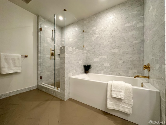 bathroom with tile patterned flooring and shower with separate bathtub