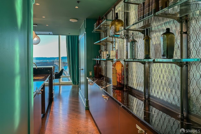 bar featuring dark wood-type flooring, a wall of windows, and fridge