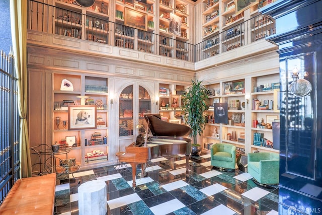 sitting room featuring built in features and a towering ceiling