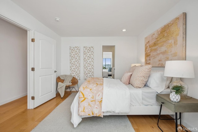 bedroom with baseboards, wood finished floors, and recessed lighting