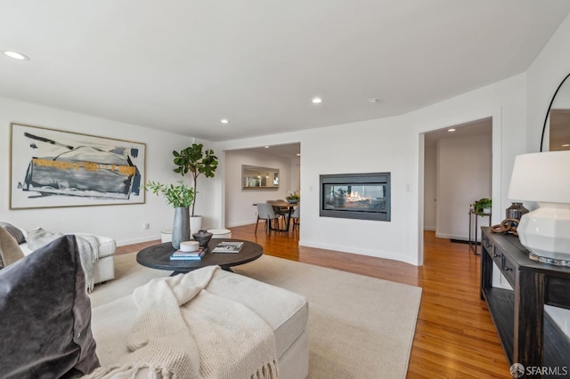 living room featuring recessed lighting, light wood-style flooring, and baseboards