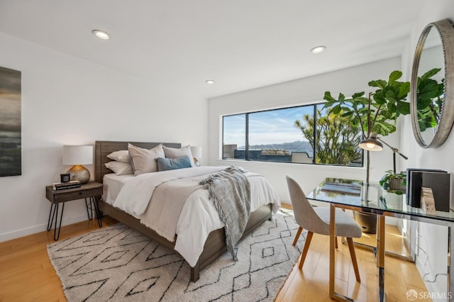 bedroom with baseboards, recessed lighting, and light wood-type flooring