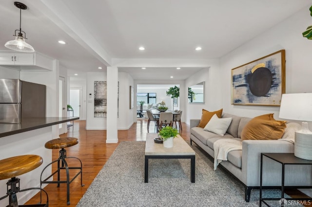living area with recessed lighting, wood finished floors, and baseboards