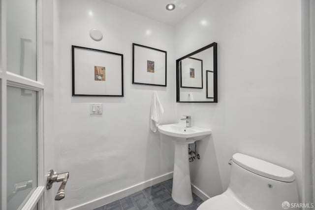 bathroom with baseboards and toilet