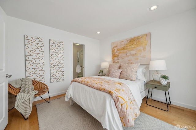 bedroom featuring baseboards, wood finished floors, and recessed lighting