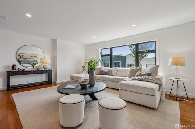 living area with baseboards, wood finished floors, and recessed lighting