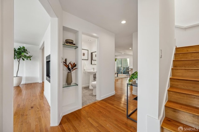 staircase featuring recessed lighting, wood finished floors, and baseboards