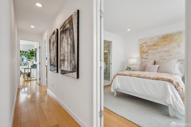 bedroom with light wood finished floors, baseboards, and recessed lighting