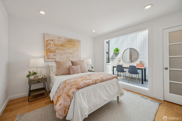 bedroom featuring baseboards, wood finished floors, and recessed lighting