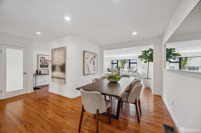 dining space with visible vents, baseboards, wood finished floors, and recessed lighting
