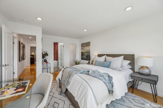 bedroom with recessed lighting, light wood-style flooring, and baseboards