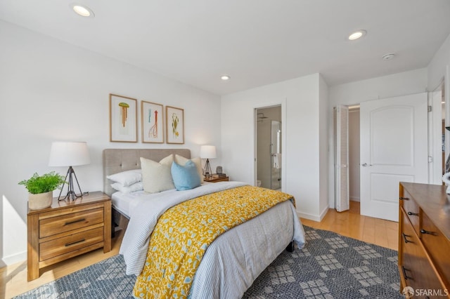 bedroom featuring ensuite bath, baseboards, light wood-style floors, and recessed lighting