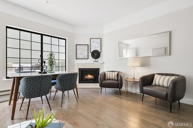 dining room with a premium fireplace and hardwood / wood-style flooring