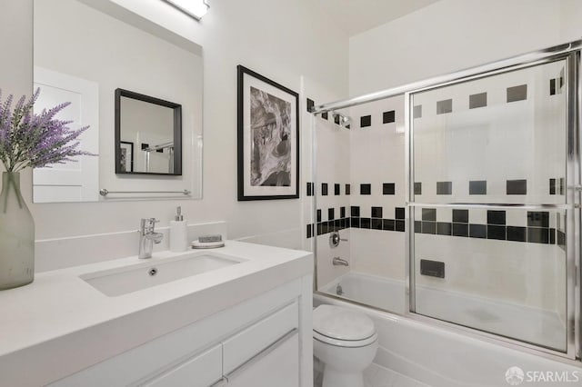 full bathroom featuring enclosed tub / shower combo, vanity, toilet, and tile patterned floors