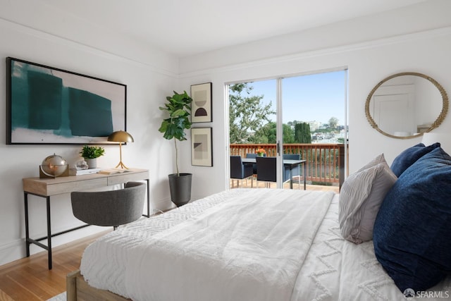 bedroom with wood-type flooring and access to exterior