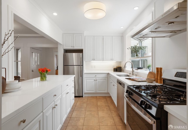 kitchen with light tile patterned flooring, sink, white cabinetry, ornamental molding, and appliances with stainless steel finishes