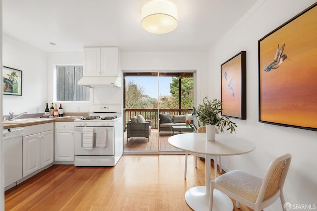 kitchen with sink, white cabinets, white appliances, and light wood-type flooring