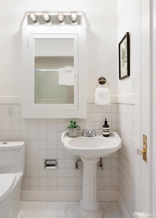 bathroom with tile walls and toilet