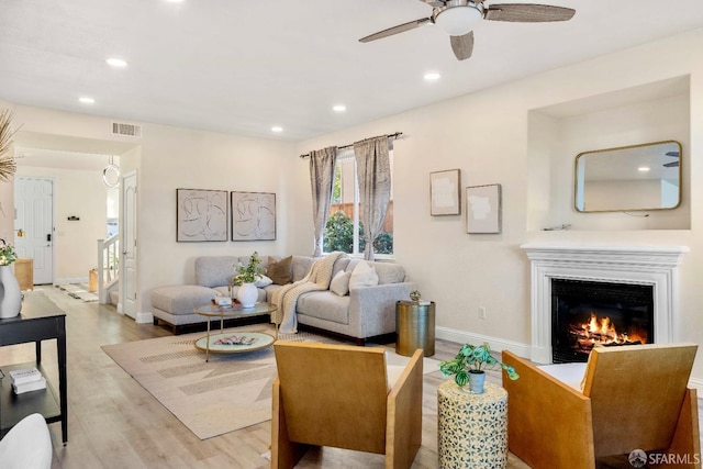 living room with ceiling fan and light wood-type flooring