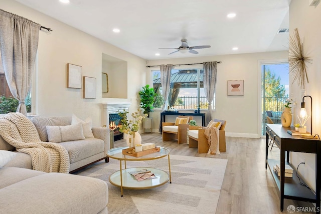 living room with ceiling fan and light hardwood / wood-style floors