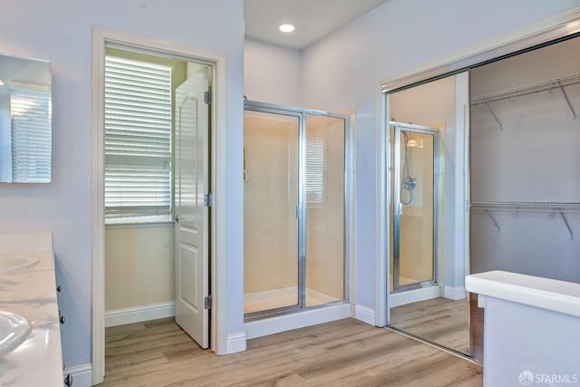 bathroom with vanity, a shower with shower door, and hardwood / wood-style floors