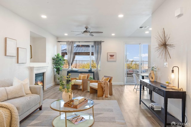 living room featuring ceiling fan and light hardwood / wood-style floors